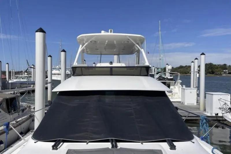 Slide: The Image of 2019 Tiara Yachts F53 Flybridge cruising on open water under clear skies. - 2
