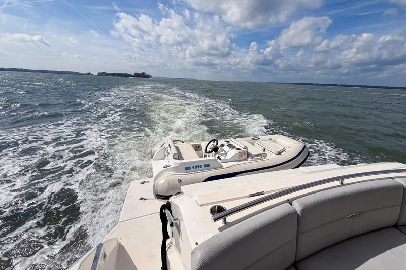 Slide: The Image of 2019 Tiara Yachts F53 Flybridge cruising with inflatable boat on open water. - 34