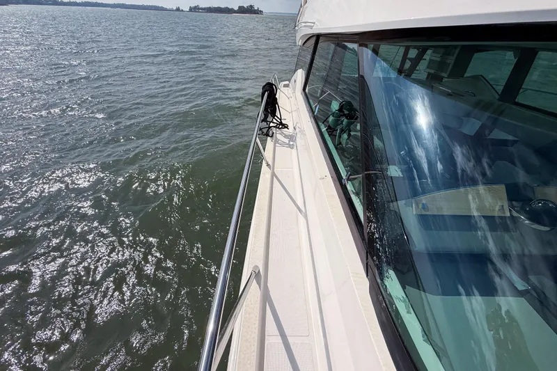 Slide: The Image of 2019 Tiara Yachts F53 Flybridge cruising on open water, reflecting sky and clouds. - 40