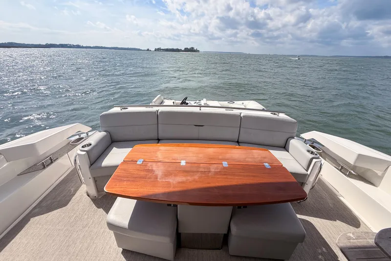 Slide: The Image of 2019 Tiara Yachts F53 Flybridge deck with seating and wooden table, ocean view. - 42