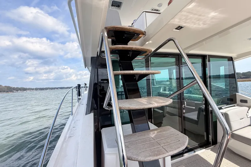 Slide: The Image of 2019 Tiara Yachts F53 Flybridge with sleek staircase and ocean view. - 45