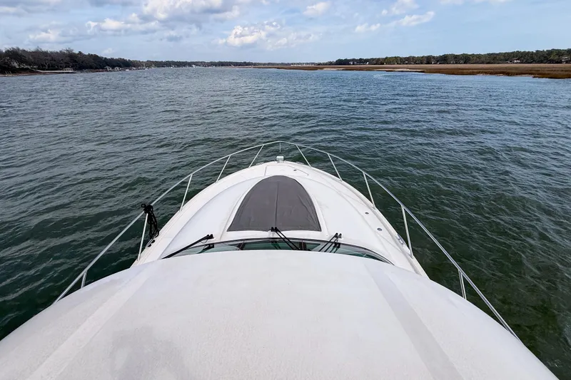 Slide: The Image of 2019 Tiara Yachts F53 Flybridge cruising on calm waters under a partly cloudy sky. - 58