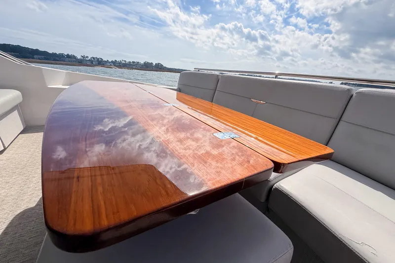 Slide: The Image of 2019 Tiara Yachts F53 Flybridge with polished wooden table and ocean view. - 61