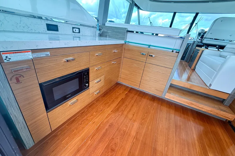 Slide: The Image of Luxurious 2019 Tiara Yachts F53 Flybridge interior with modern kitchen and wood flooring. - 65