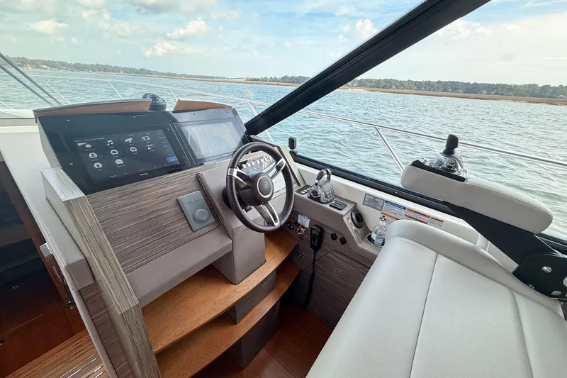 Slide: The Image of 2019 Tiara Yachts F53 Flybridge helm with modern controls and scenic water view. - 70