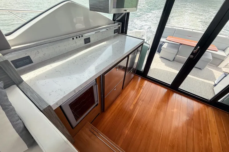 Slide: The Image of Luxurious interior of 2019 Tiara Yachts F53 Flybridge with sleek countertops and wooden flooring. - 75
