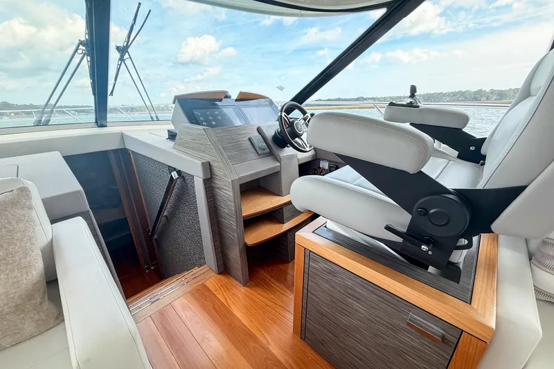 Slide: The Image of 2019 Tiara Yachts F53 Flybridge helm with modern controls and luxurious seating. - 79