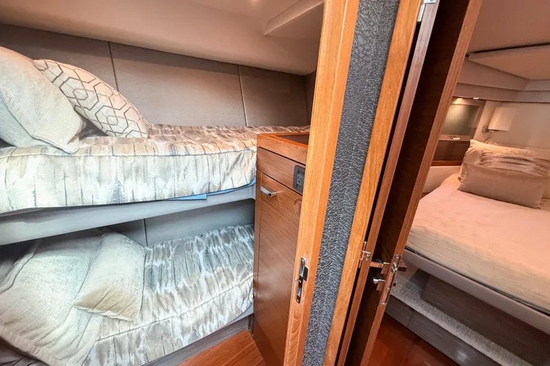 Slide: The Image of 2019 Tiara Yachts F53 Flybridge interior with cozy bunk beds and elegant wood finishes. - 90