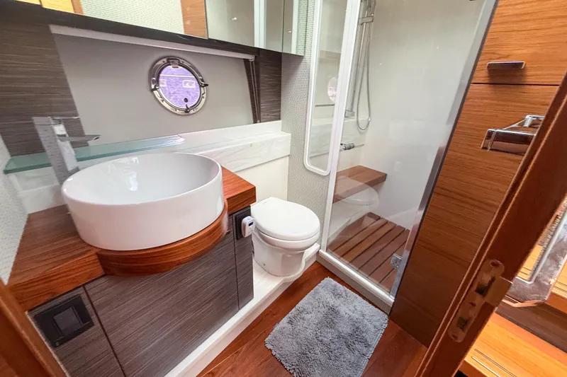 Slide: The Image of Luxurious bathroom in 2019 Tiara Yachts F53 Flybridge with modern fixtures and wood accents. - 97