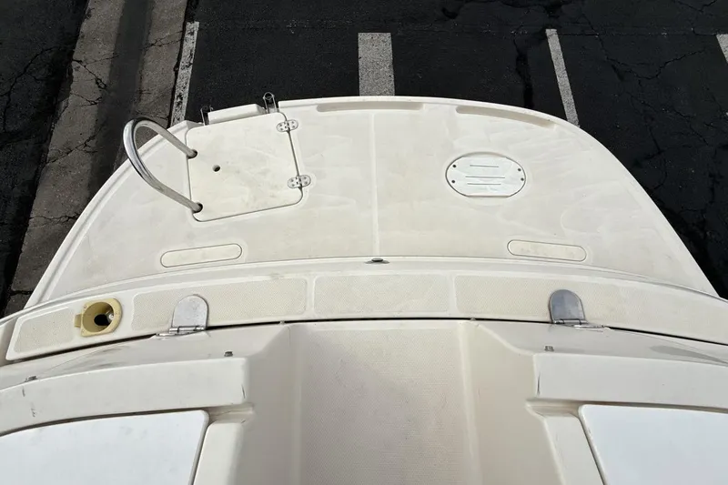 Slide: The Image of 2005 Monterey 233 Explorer Sport boat deck with ladder and hatch, parked on asphalt. - 19