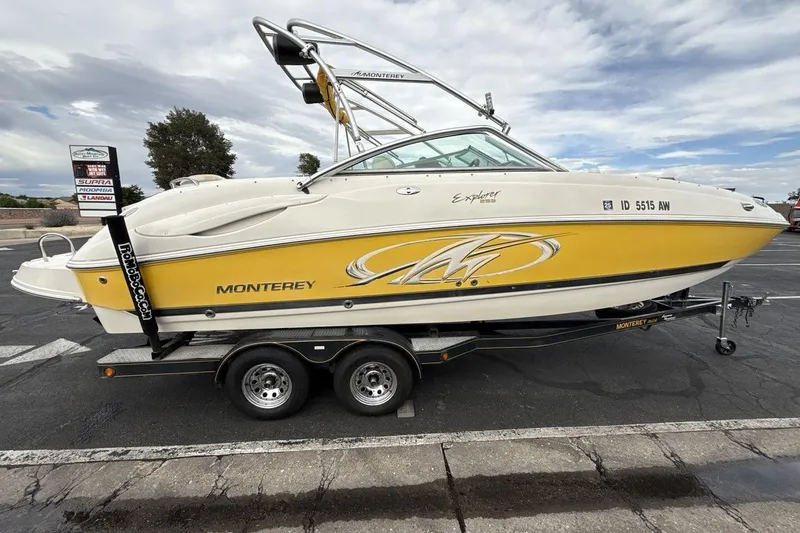 Slide: The Image of 2005 Monterey 233 Explorer Sport boat on trailer, yellow and white design, parked outdoors. - 6