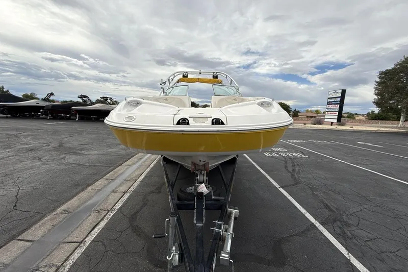 Slide: The Image of 2005 Monterey 233 Explorer Sport boat on trailer in parking lot, cloudy sky background. - 8