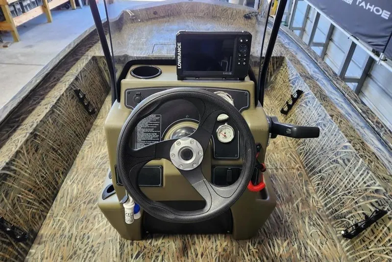 Slide: The Image of 2025 Tracker Grizzly 1860 CC boat dashboard with steering wheel and navigation system. - 6