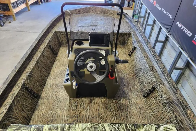 Slide: The Image of 2025 Tracker Grizzly 1860 CC boat interior with camouflage design and central steering console. - 7