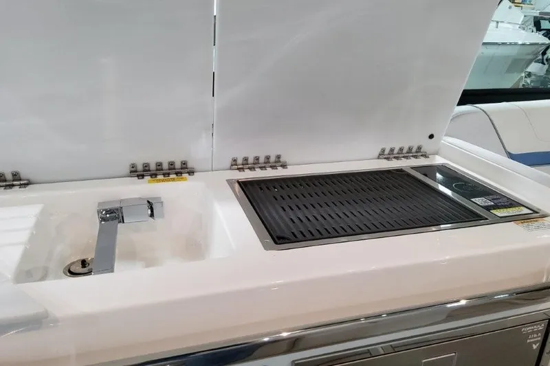 Slide: The Image of 2026 Formula 360 Crossover Bowrider I/O boat kitchen with sink and grill. - 33