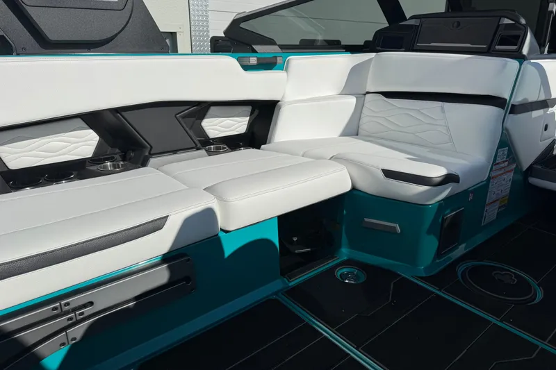 Slide: The Image of 2026 Supra SA 575 boat interior with white and teal seating, cup holders, and modern design. - 8