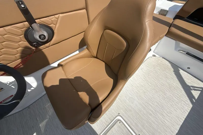 Slide: The Image of 2024 Four Winns H1 OB boat interior with tan leather seat and steering controls. - 13