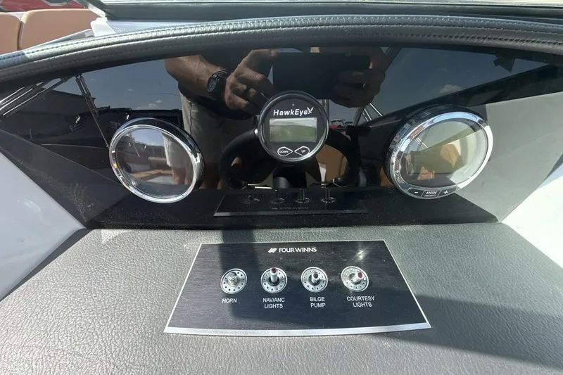 Slide: The Image of 2024 Four Winns H1 OB dashboard with HawkEye display and control switches. - 15