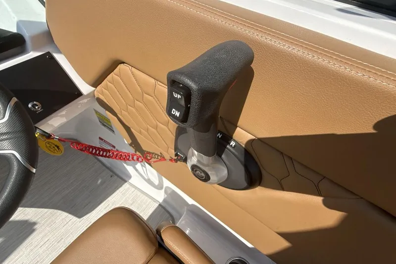 Slide: The Image of 2024 Four Winns H1 OB boat throttle control on tan interior panel. - 16