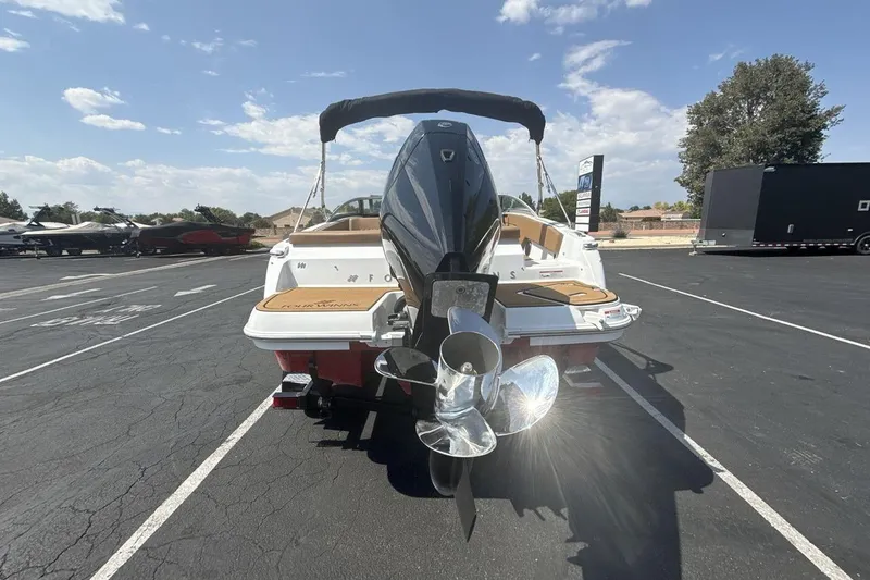 Slide: The Image of 2024 Four Winns H1 OB boat, rear view with outboard motor, parked outdoors. - 4