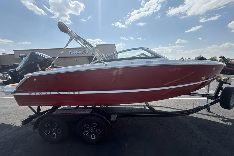 Slide: The Image of 2024 Four Winns H1 OB boat on trailer, red hull, sunny day. - 6