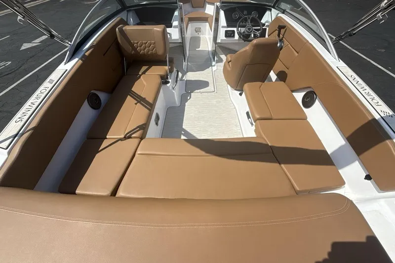 Slide: The Image of 2024 Four Winns H1 OB boat interior with tan seating and modern dashboard. - 9