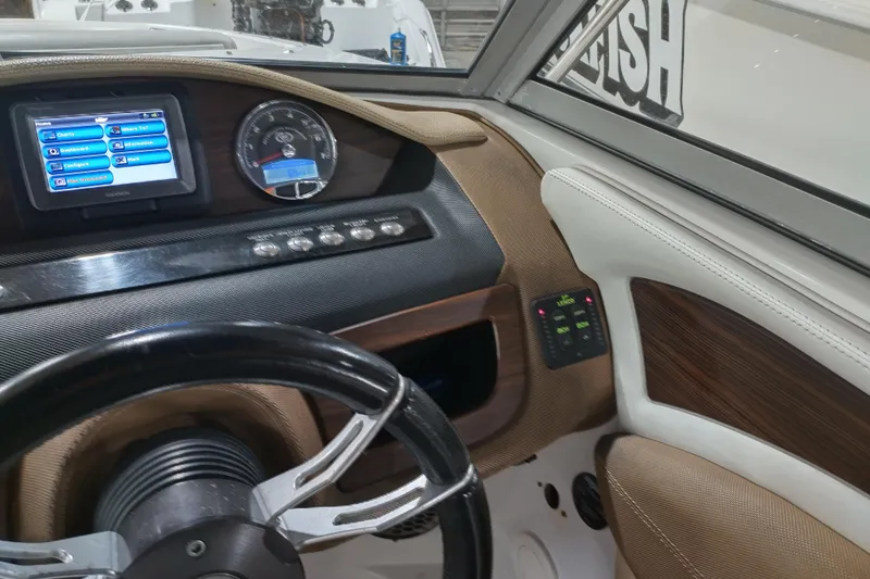 Slide: The Image of Dashboard of a 2015 Cobalt 24SD boat with steering wheel and digital display. - 19