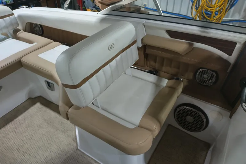 Slide: The Image of 2015 Cobalt 24SD boat interior with beige and white seating, speakers, and storage compartments. - 23
