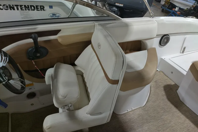 Slide: The Image of 2015 Cobalt 24SD boat interior with beige and white seating, steering wheel, and controls. - 24