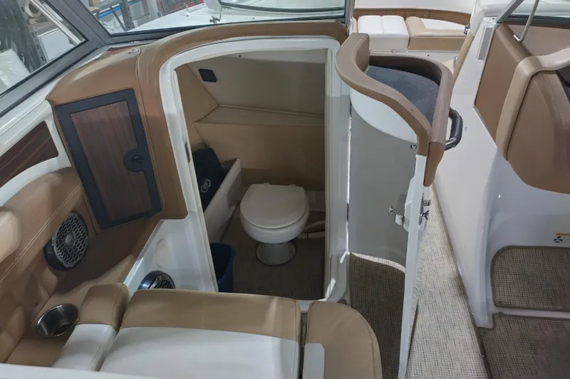 Slide: The Image of 2015 Cobalt 24SD boat interior with a compact bathroom and seating area. - 28