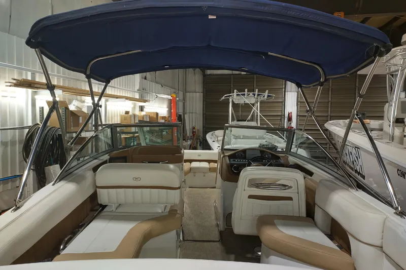 Slide: The Image of 2015 Cobalt 24SD boat interior with blue canopy in a storage facility. - 31