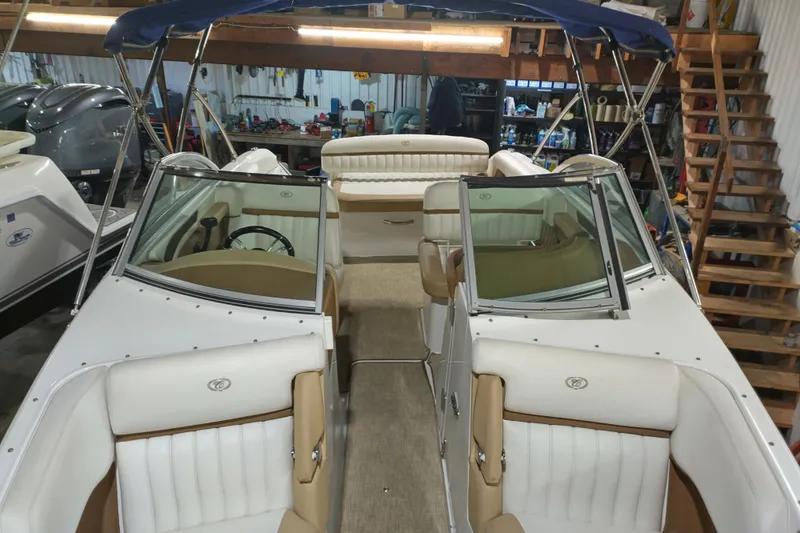 Slide: The Image of 2015 Cobalt 24SD boat interior with white and tan seating in a garage setting. - 32