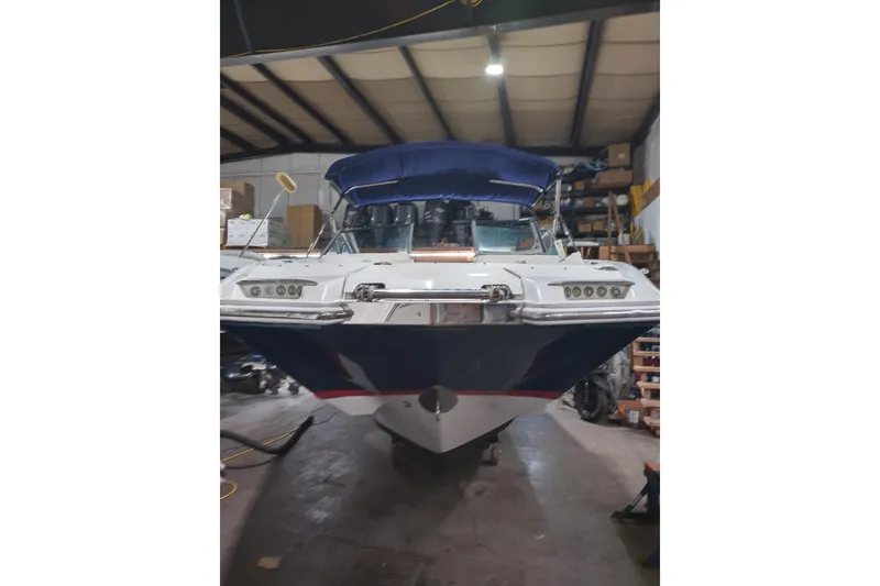 Slide: The Image of 2015 Cobalt 24SD boat in a storage facility, featuring a blue canopy. - 6