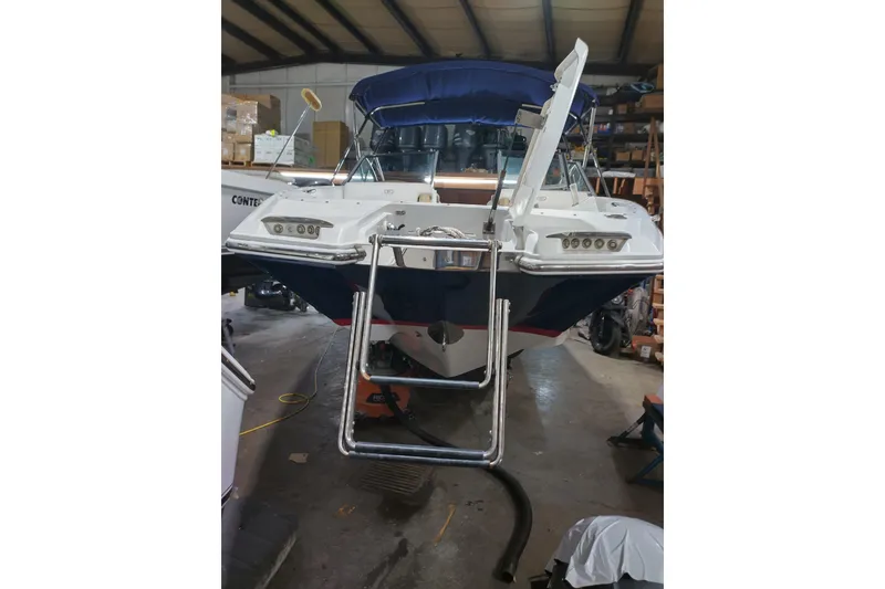 Slide: The Image of 2015 Cobalt 24SD boat in a warehouse with a swim ladder. - 7