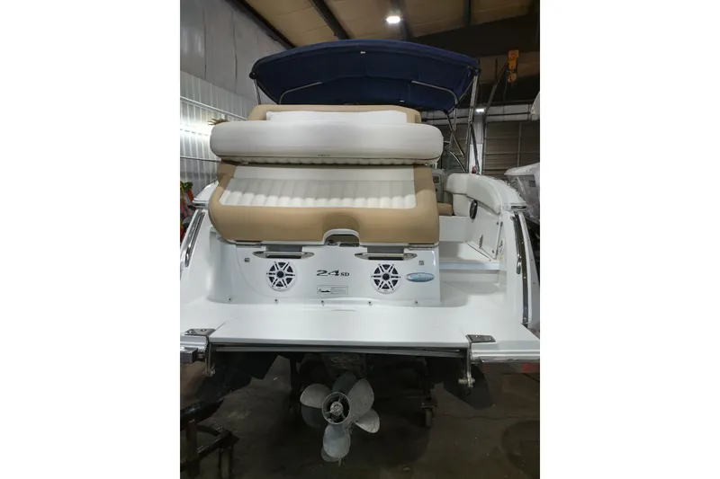 Slide: The Image of 2015 Cobalt 24SD boat rear view with seating and propeller in a garage. - 9