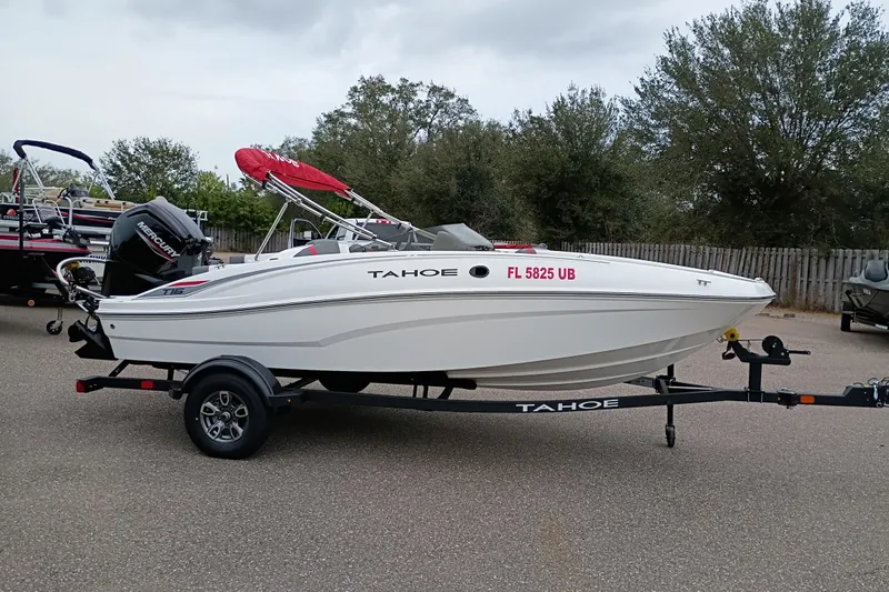 Slide: The Image of 2026 Tahoe T16 boat with trailer, parked outdoors, featuring a red canopy and Mercury engine. - 5