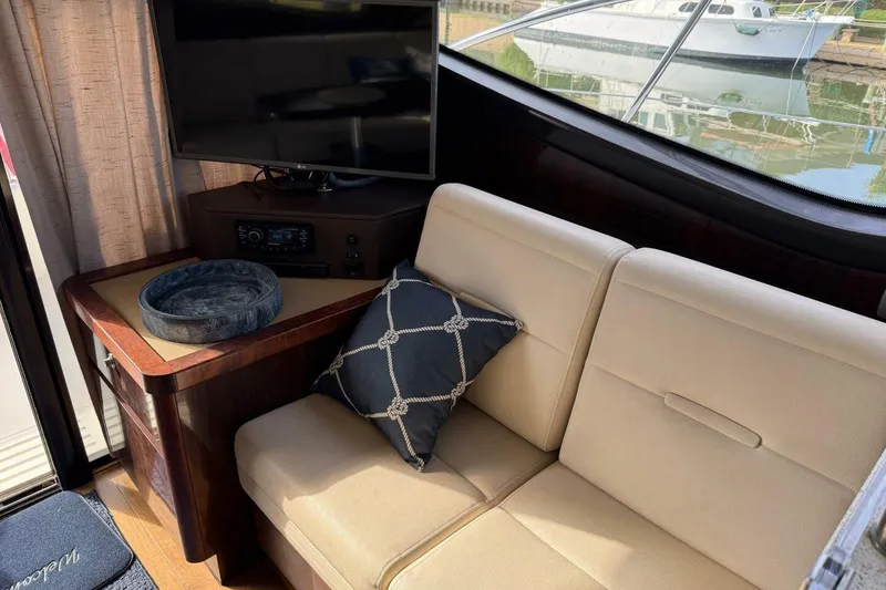 Slide: The Image of Interior of 2016 Sea Ray Sundancer 400 yacht with beige seating and a TV. - 18