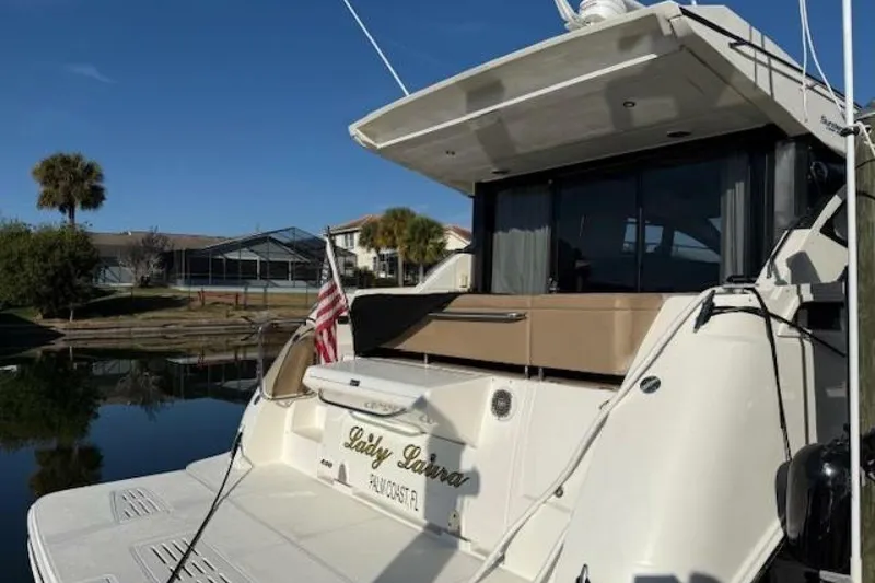 Slide: The Image of 2016 Sea Ray Sundancer 400 yacht docked, featuring sleek design and American flag. - 36