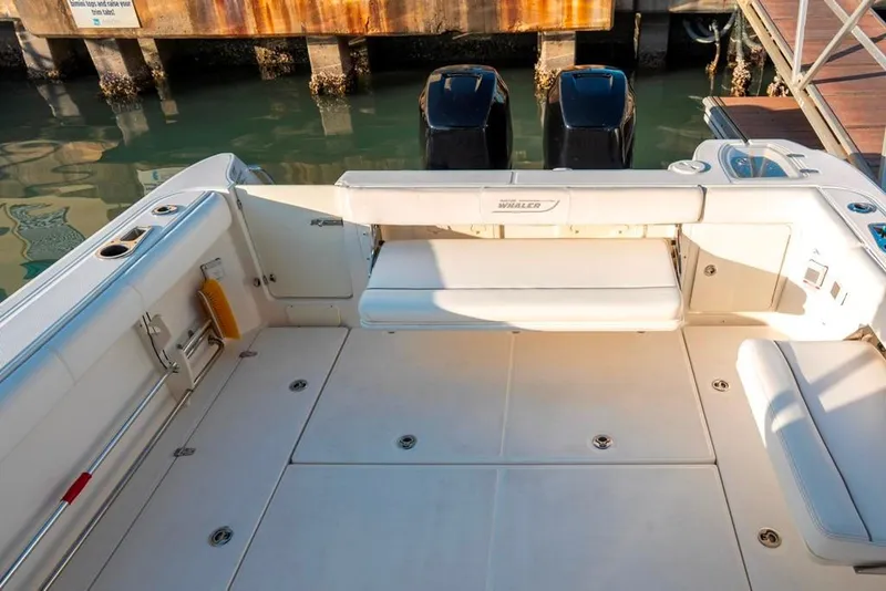 Slide: The Image of 2014 Boston Whaler 315 Conquest boat deck with seating and twin engines. - 15