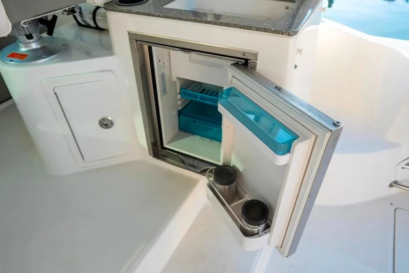 Slide: The Image of 2014 Boston Whaler 315 Conquest boat interior with open mini fridge. - 16