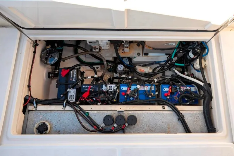Slide: The Image of 2014 Boston Whaler 315 Conquest engine compartment with batteries and wiring. - 17
