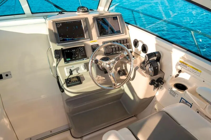 Slide: The Image of 2014 Boston Whaler 315 Conquest helm with navigation screens and steering wheel. - 18