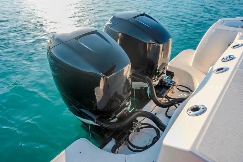 Slide: The Image of 2014 Boston Whaler 315 Conquest with dual outboard engines on clear blue water. - 21