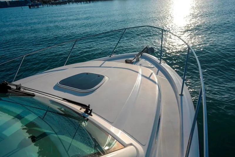 Slide: The Image of 2014 Boston Whaler 315 Conquest boat on calm water, sun reflecting on surface. - 23