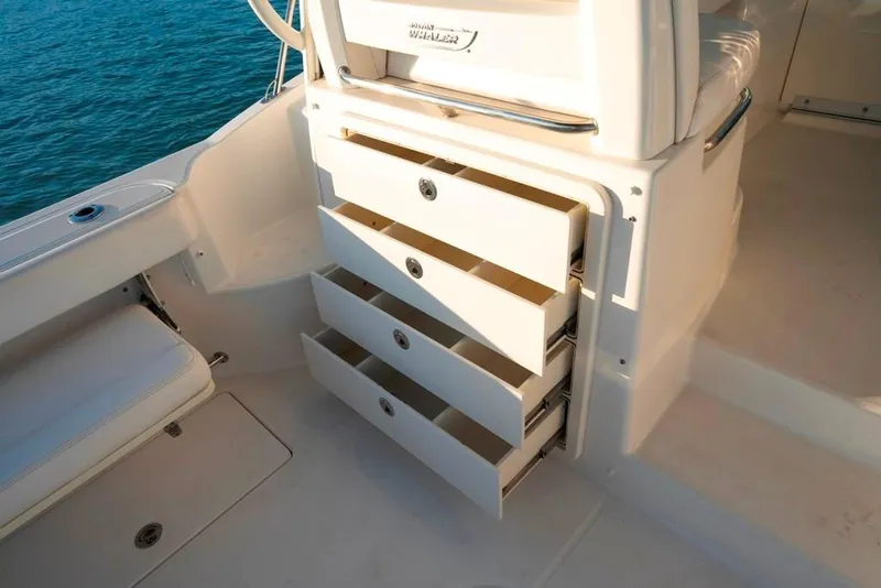 Slide: The Image of 2014 Boston Whaler 315 Conquest boat interior with open storage drawers. - 29