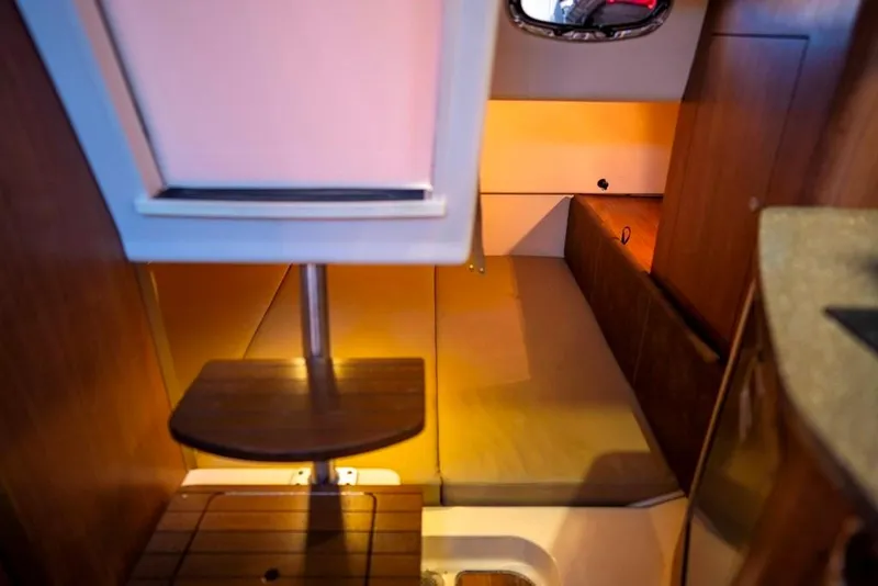 Slide: The Image of 2014 Boston Whaler 315 Conquest cabin interior with wooden steps and cozy sleeping area. - 35