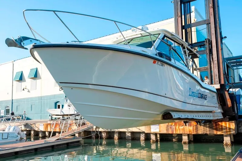 Slide: The Image of 2014 Boston Whaler 315 Conquest boat lifted at marina dock. - 5