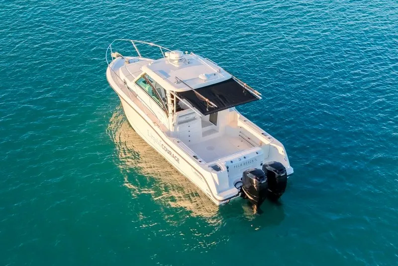 Slide: The Image of 2014 Boston Whaler 315 Conquest boat on clear blue water, rear view. - 7