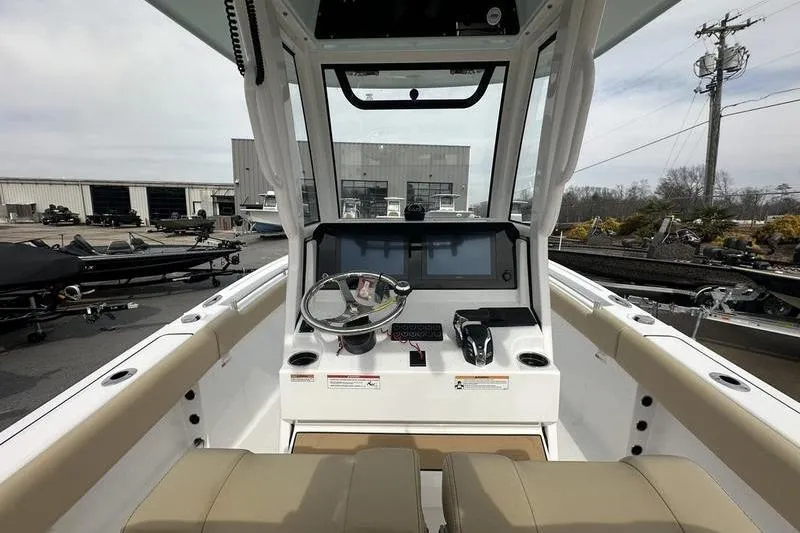 Slide: The Image of 2026 Sportsman Heritage 231 Center Console boat interior with steering wheel and control panel. - 18