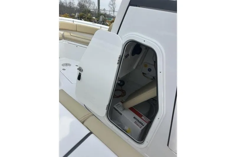 Slide: The Image of 2026 Sportsman Heritage 231 Center Console storage compartment with open hatch, revealing interior equipment. - 6